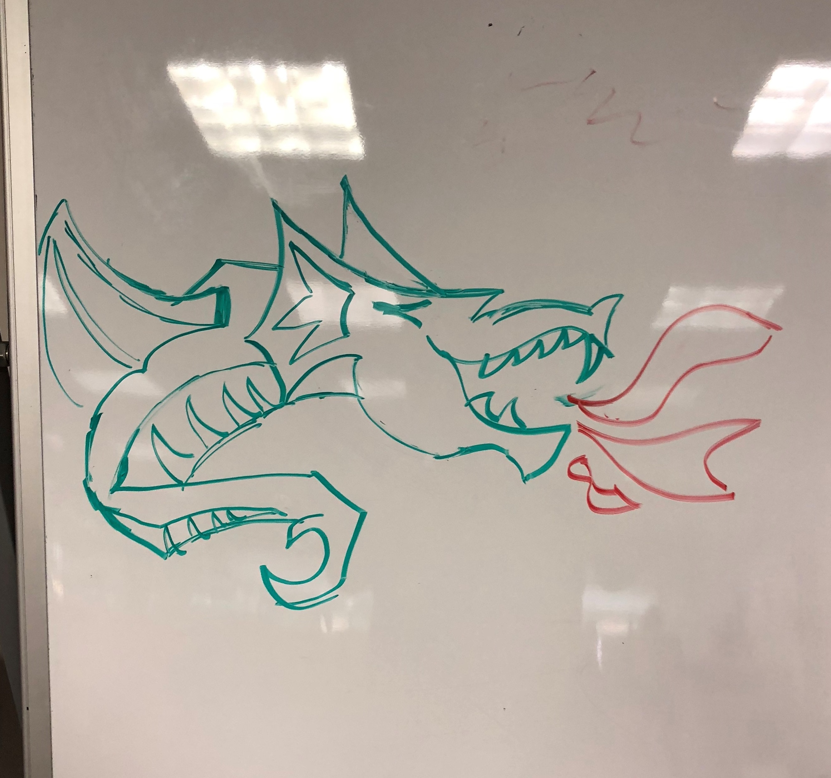 drawing of a dragon breathing fire on a dry erase board